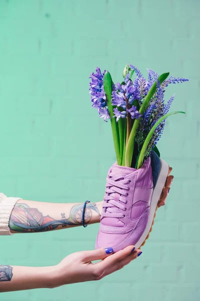 Cropped image of girl holding shoe with hyacinth flowers — Stock Photo