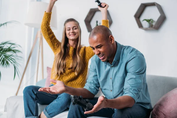 Girlfriend winning video game in african american boyfriend — Stock Photo
