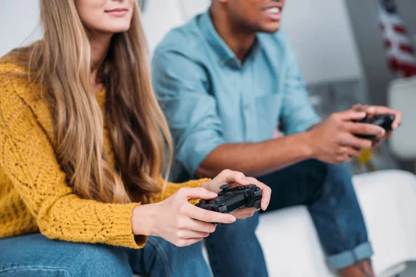 Imagem cortada de casal multicultural jogando videogame em casa — Fotografia de Stock