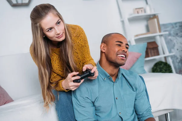 Lächelndes multikulturelles Paar beim Videospiel zu Hause — Stockfoto