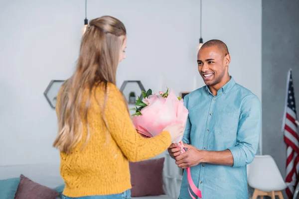 Copain afro-américain présentant bouquet à petite amie — Photo de stock