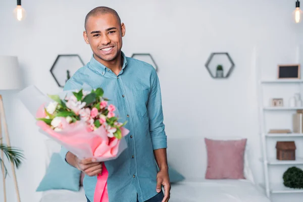 African american man showing bouquet of flowers — Stock Photo