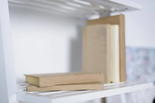 Books on white shelves in light apartment — Stock Photo