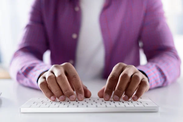 Abgeschnittenes Bild eines Afroamerikaners, der an der Tastatur tippt — Stockfoto