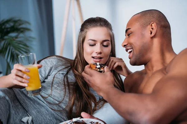 Africano americano novio alimentación caucásico novia - foto de stock