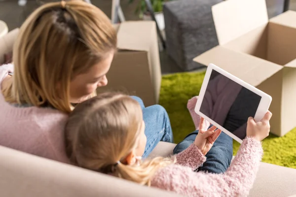 Mother and daughter using digital tablet with blank screen while moving home — Stock Photo