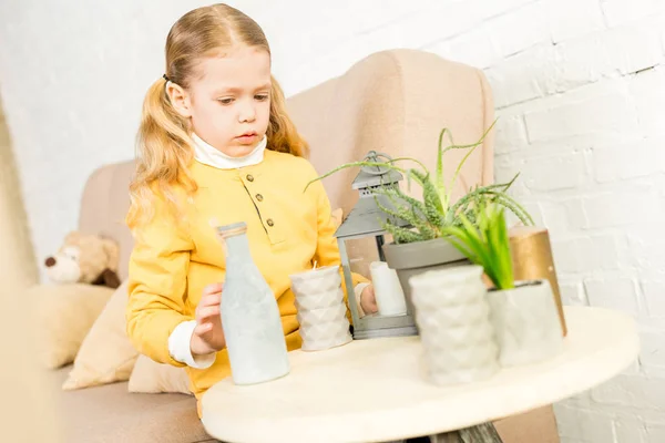 Niedliches kleines Kind arrangiert beim Umzug Gegenstände auf dem Tisch — Stockfoto