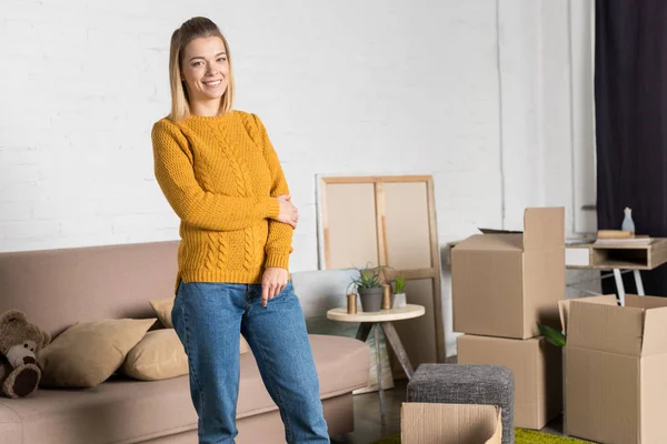 Beautiful young woman smiling at camera while moving home — Stock Photo
