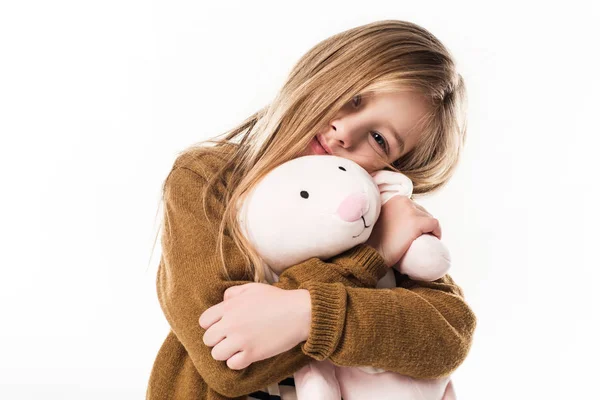 Красивый маленький ребенок обнимается с мягкой игрушкой кролика изолированы на белом — стоковое фото