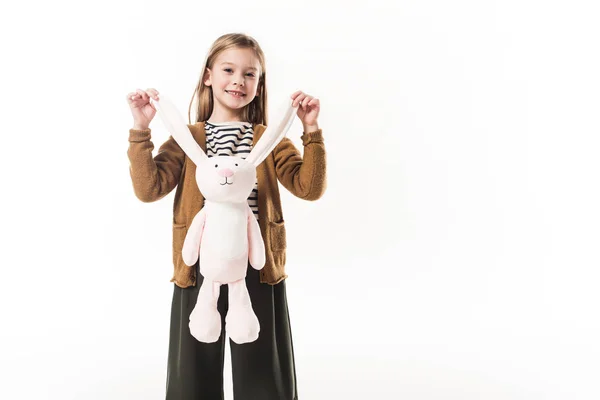 Adorable little child holding soft toy bunny by ears isolated on white — Stock Photo