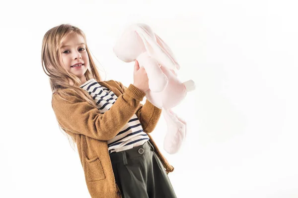 Linda criança com coelhinho de brinquedo macio isolado no branco — Fotografia de Stock