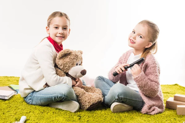 Little sisters spending time together while sitting on floor isolated on white — Stock Photo