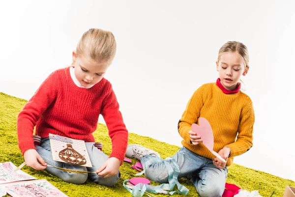 Adorables hermanitas haciendo bricolaje tarjetas de felicitación aisladas en blanco - foto de stock