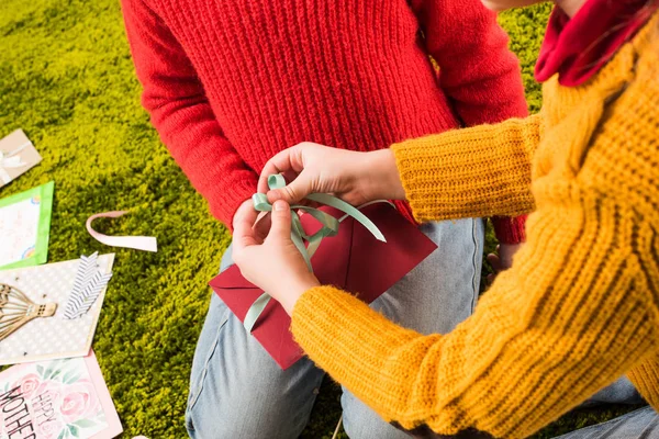 Colpo ritagliato di bambini piccoli legando fiocco sulla busta di saluto fatta a mano — Foto stock