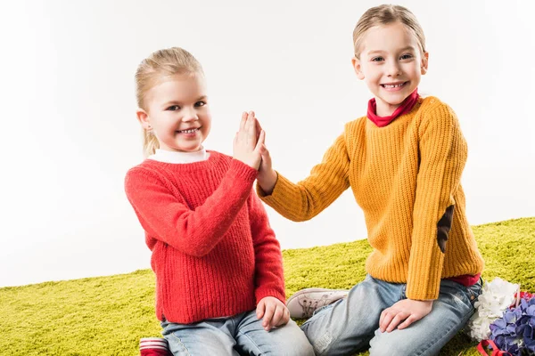 Kleine Schwestern geben High Five White sitzen auf dem Boden zusammen isoliert auf weiß — Stockfoto