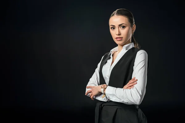 Young beautiful businesswoman with crossed arms, isolated on black — Stock Photo