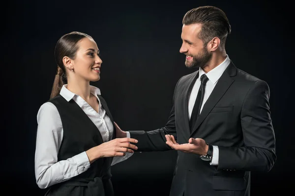 Alegres empresarios discutiendo el trabajo, aislados en negro - foto de stock