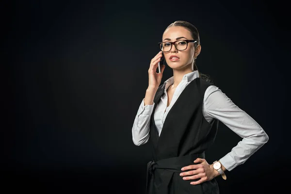 Jovem bela empresária falando no smartphone, isolado no preto — Stock Photo