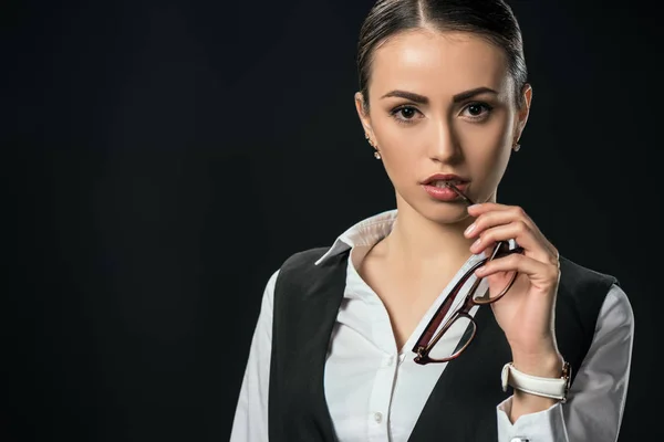 Молода вдумлива бізнес-леді з окулярами, ізольована на чорному — стокове фото