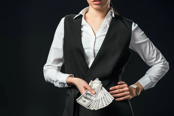 Vista recortada de la mujer de negocios sosteniendo billetes de dólar, aislado en negro - foto de stock