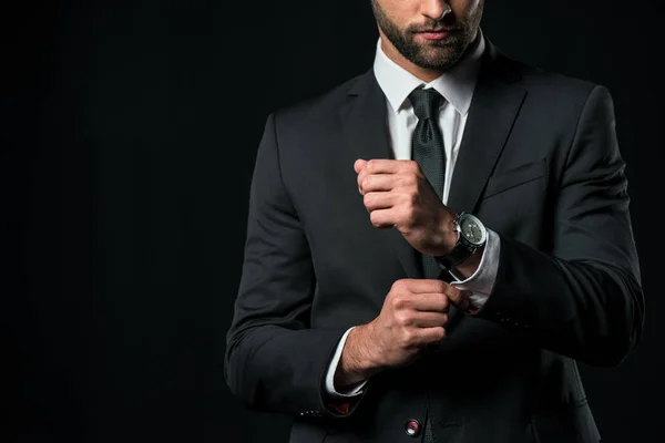 Cropped view of businessman in jacket with wristwatch, isolated on black — Stock Photo
