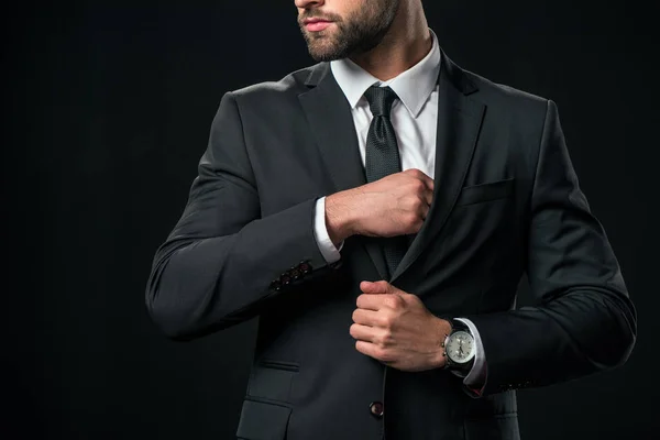 Recortado vista de hombre de negocios tomando algo de bolsillo de la chaqueta, aislado en negro - foto de stock