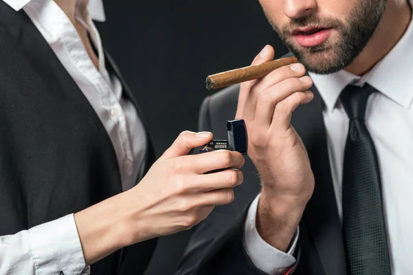 Cropped view of secretary lightning cigar for boss, isolated on black — Stock Photo