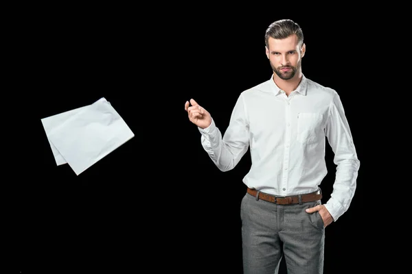 Guapo hombre de negocios en camisa blanca arrojando documentos, aislado en negro - foto de stock