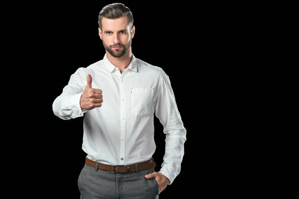 Hombre de negocios guapo en mostrar el pulgar hacia arriba, aislado en negro - foto de stock