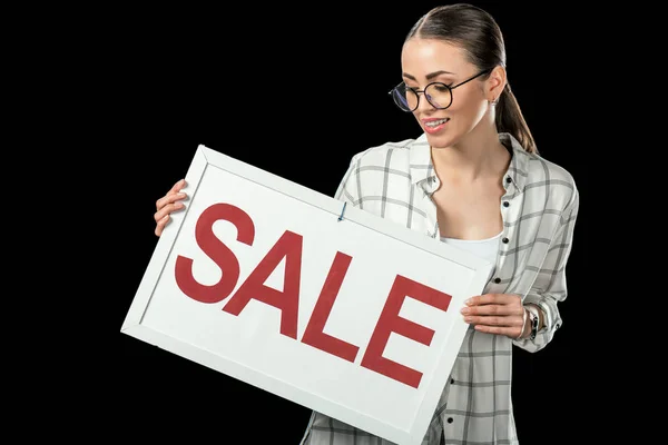 Beautiful girl holding sale sign, isolated on black — Stock Photo