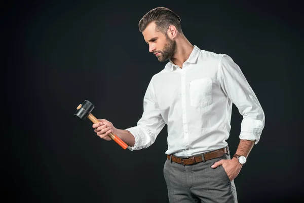 Schöner Geschäftsmann in weißem Hemd mit Hammer, isoliert auf schwarz — Stockfoto