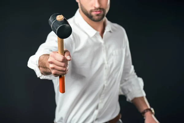 Vista recortada del hombre en camisa blanca sosteniendo martillo, aislado en negro - foto de stock