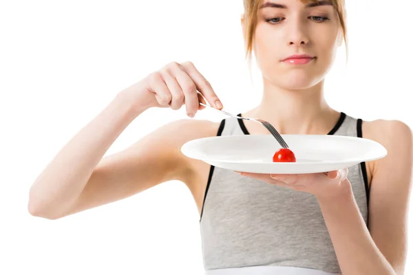 Attraktive schlanke Frau isst kleine Kirschtomaten isoliert auf weiß — Stockfoto