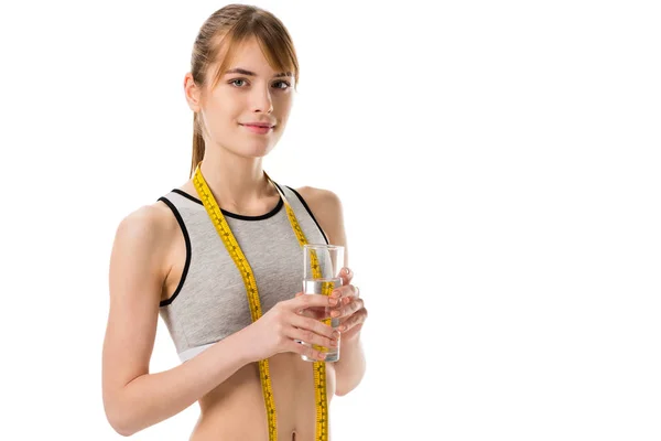 Young slim woman wih measuring tape holding glass of water isolated on white — Stock Photo
