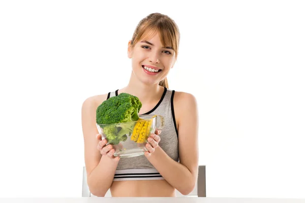 Felice donna magra con broccoli ricoperti di metro a nastro in ciotola isolata su bianco — Foto stock