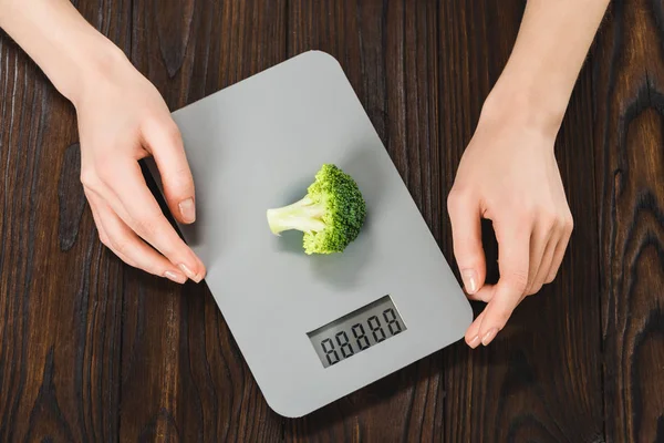 Plan recadré de la femme mesurant le poids du brocoli — Photo de stock