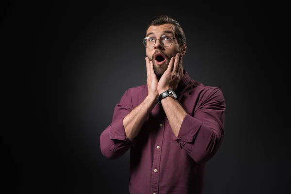 Retrato de homem chocado em óculos olhando para longe isolado em preto — Fotografia de Stock