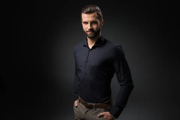 Retrato de homem sorridente com as mãos em bolsos isolados em preto — Fotografia de Stock