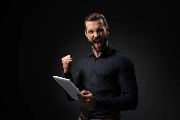 Portrait d'homme excité avec tablette numérique isolé sur noir — Photo de stock