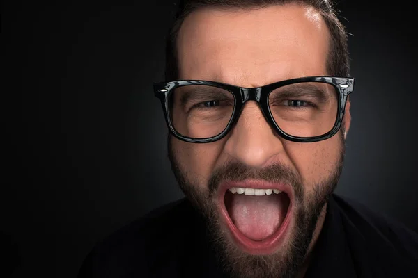 Retrato del hombre con anteojos gritando aislado sobre negro - foto de stock