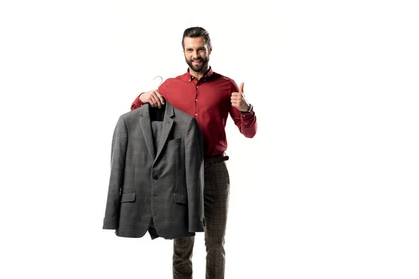 Elegante hombre con chaqueta en la mano mostrando el pulgar hacia arriba aislado en blanco - foto de stock