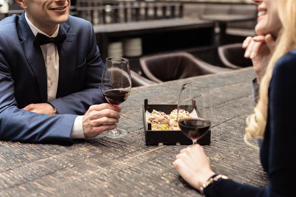 Recortado disparo de feliz pareja adulta beber vino en el restaurante - foto de stock