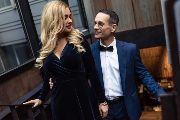 Bella coppia adulta in abiti alla moda salendo le scale — Foto stock