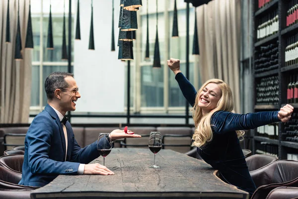 Side view of handsome adult man proposing his girlfriend at restaurant — Stock Photo