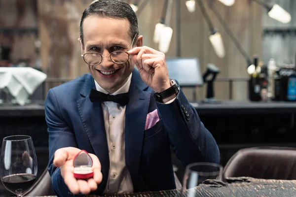 Schöner Mann im eleganten Anzug macht Vorschlag in Restaurant — Stockfoto