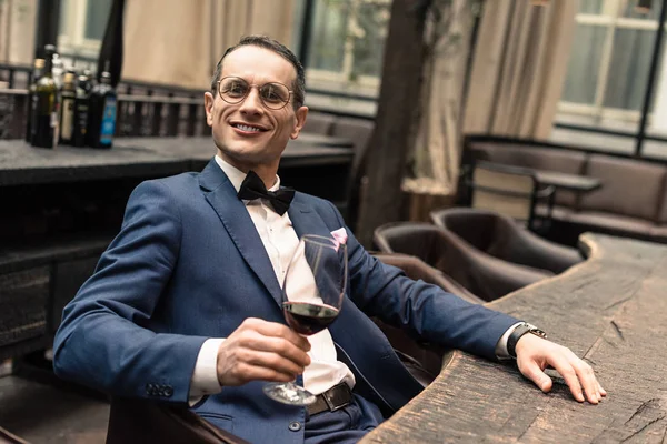 Handsome adult man in stylish suit with glass of red wine at restaurant — Stock Photo