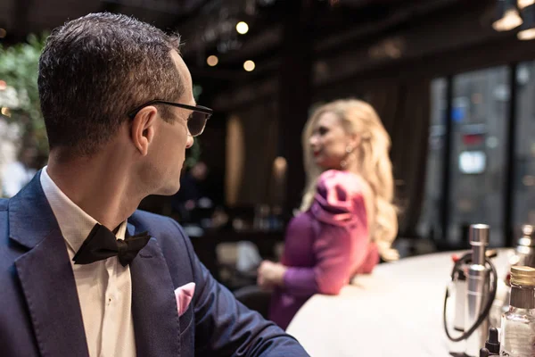 Handsome adult man looking at woman leaning at bar counter — Stock Photo