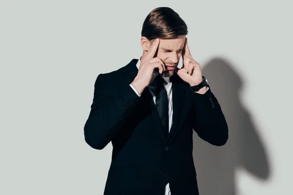 Geschäftsmann im Anzug leidet unter Kopfschmerzen auf weißem Hintergrund — Stockfoto