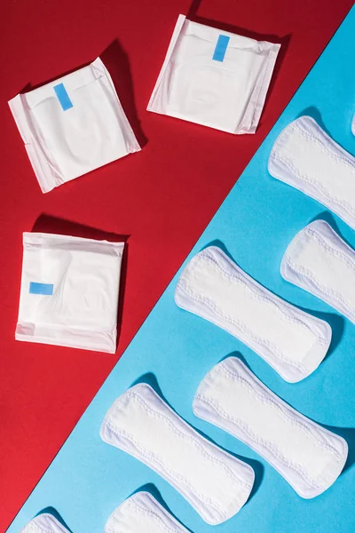 Top view of pads and daily liners on red and blue — Stock Photo