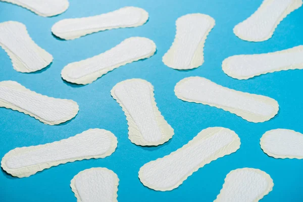 Scattered protective daily pads on blue — Stock Photo